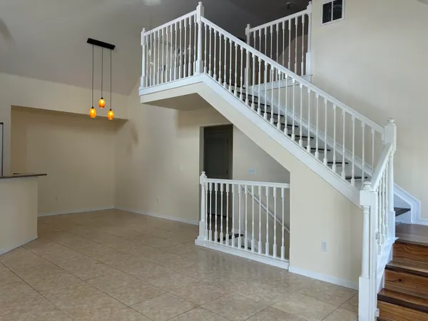 a view of staircase with railing and white walls