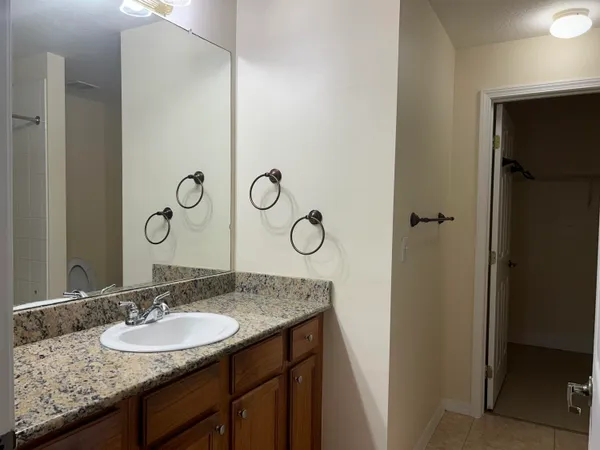 a bathroom with a granite countertop sink and a mirror