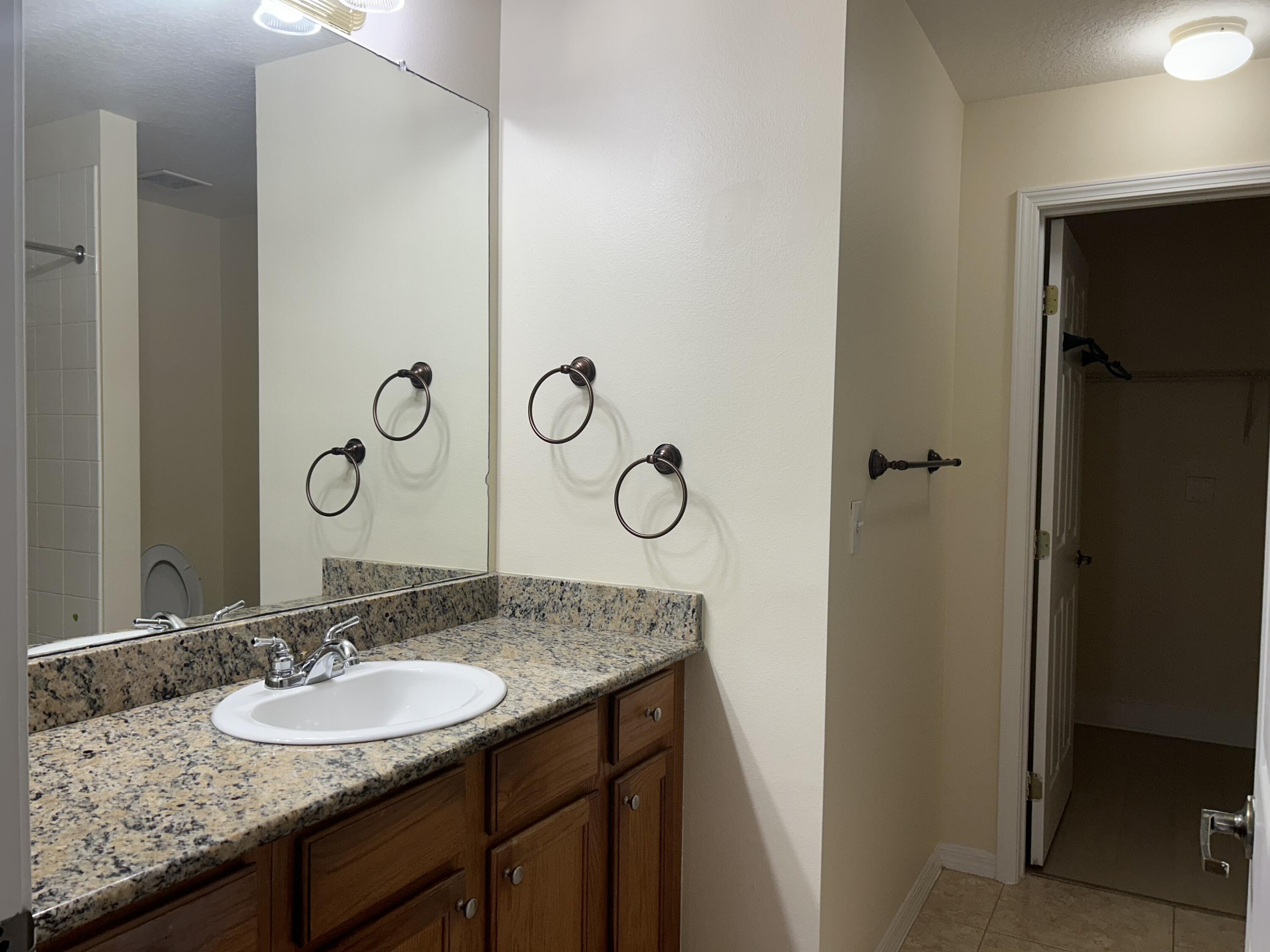 1687 Southeast Pomeroy Street Stuart, FL 34997 - Photo 10 of 20 a bathroom with a granite countertop sink and a mirror