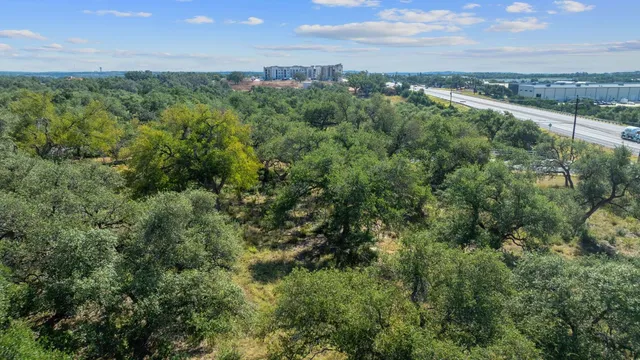 an aerial view of a city with lots of residential buildings ocean and mountain view in back