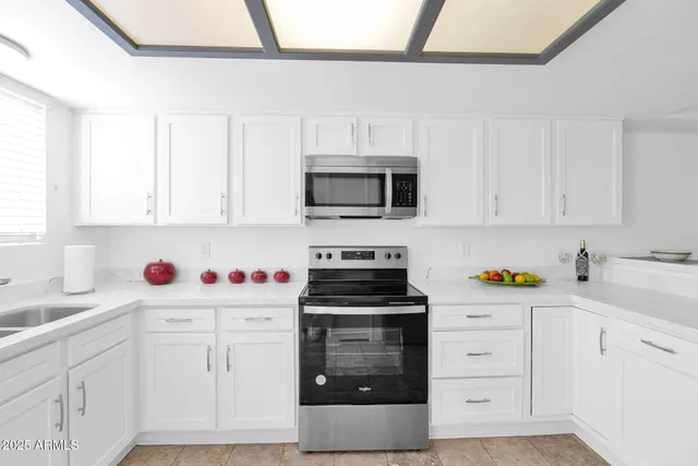 a kitchen with white cabinets and appliances