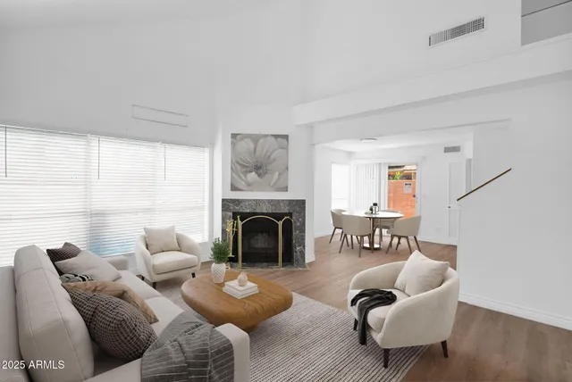 an empty room with wooden floor fireplace and windows