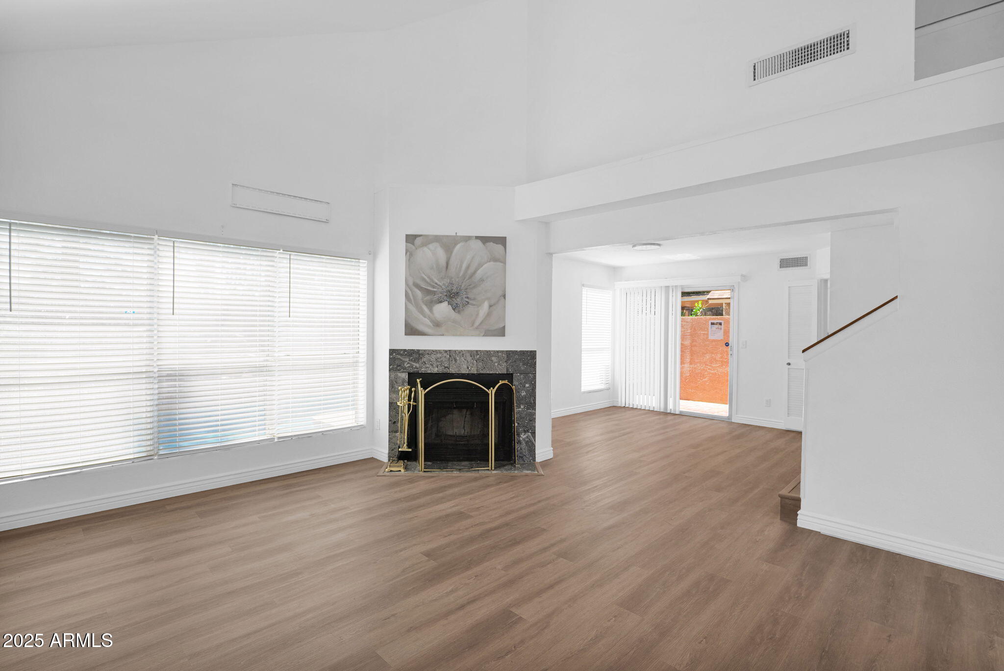 1121 West Manor Street Chandler, AZ 85224 - Photo 7 of 19 an empty room with wooden floor fireplace and windows