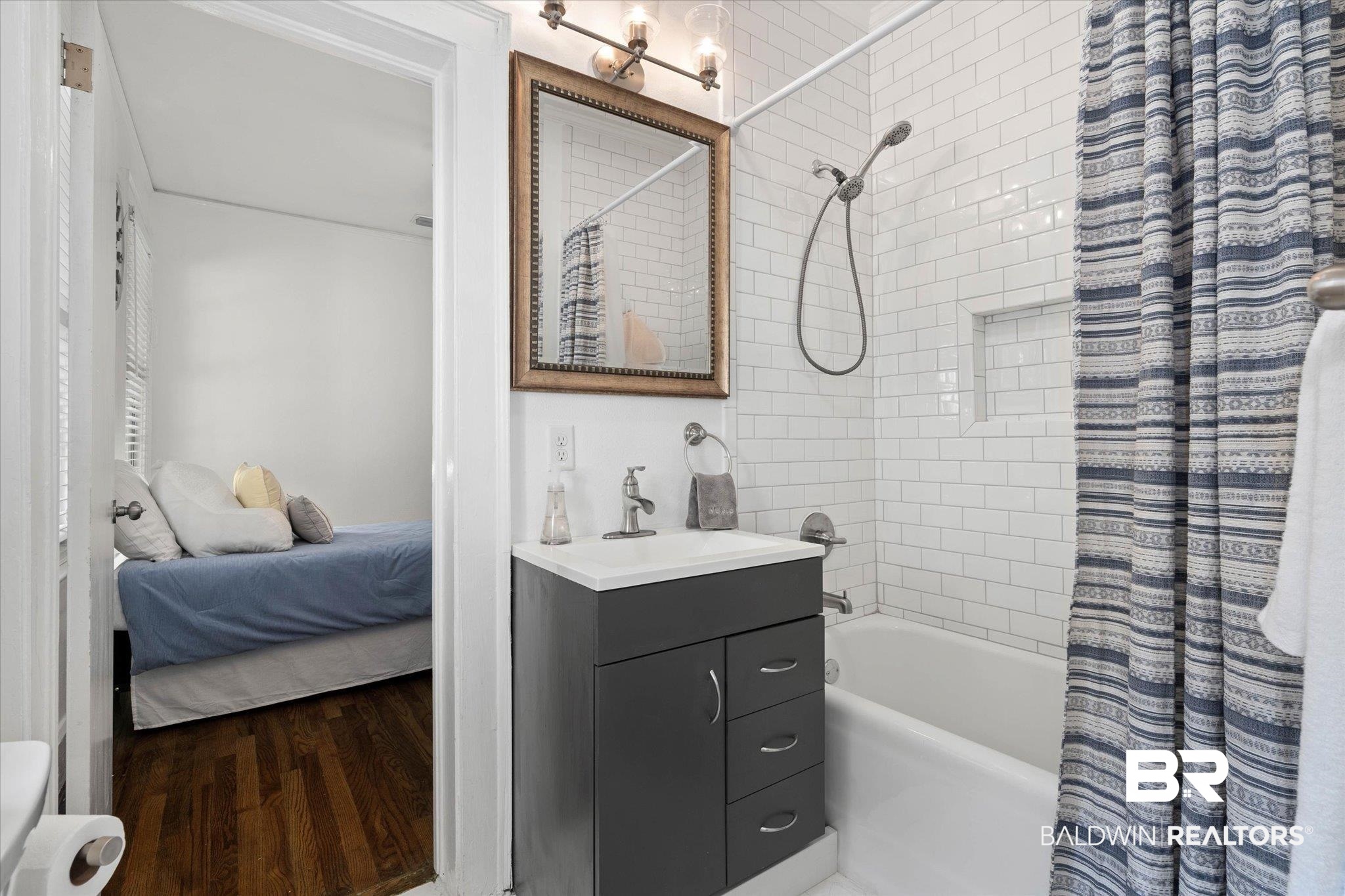 1910 Hunter Avenue Mobile, AL 36606 - Photo 15 of 21 Full bathroom featuring vanity, shower / bath combination with curtain, wood finished floors, toilet, and ensuite bathroom