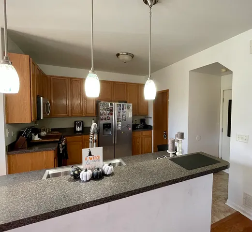 a kitchen with granite countertop a sink a counter top space appliances and cabinets