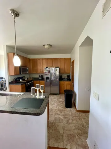 a kitchen with stainless steel appliances granite countertop a sink a stove and a refrigerator