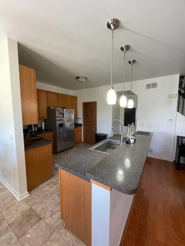 a kitchen with stainless steel appliances granite countertop a sink a counter space and cabinets