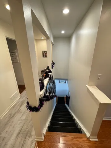 a view of a hallway with wooden floor and staircase