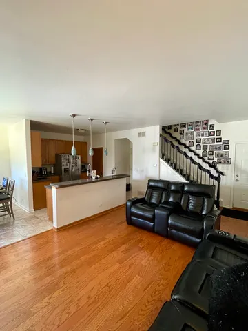 a living room with furniture a flat screen tv and kitchen view