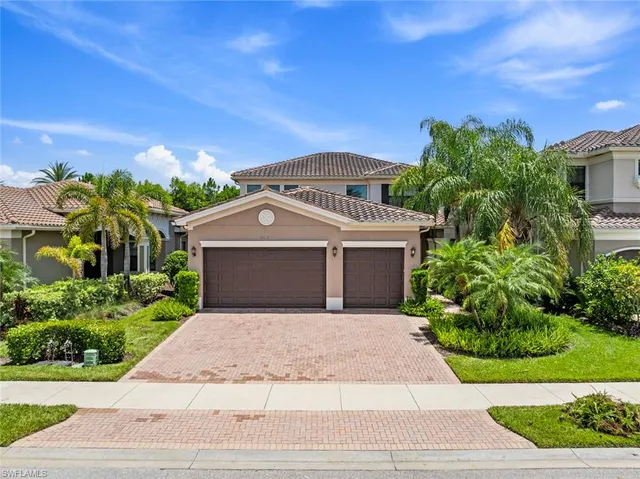 a front view of a house with a yard and potted plants