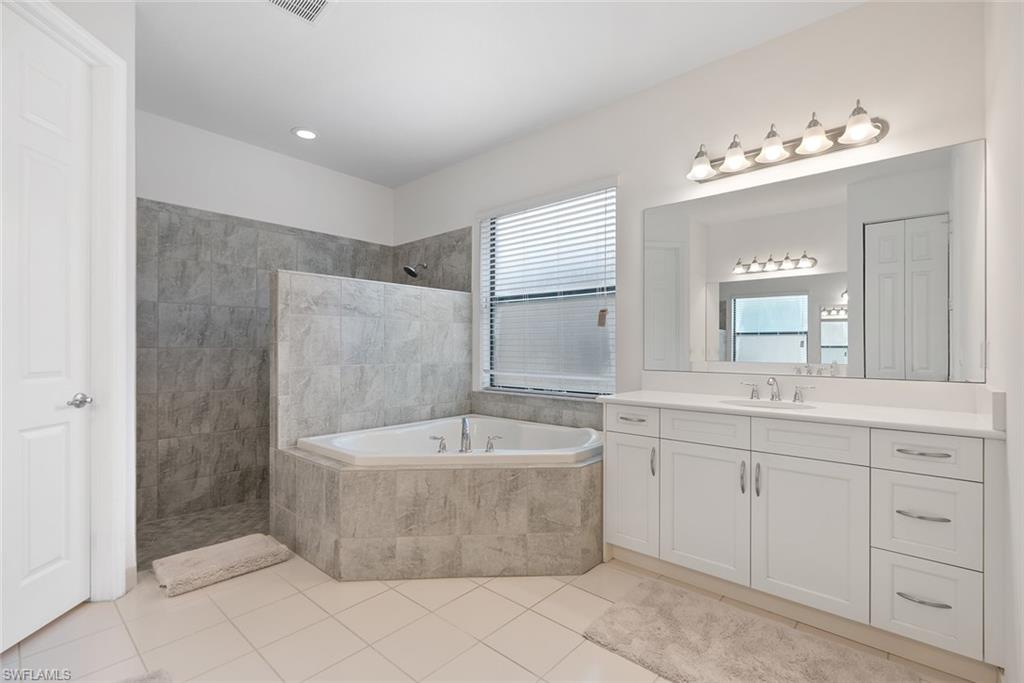 13750 Callisto Avenue Naples, FL 34109 - Photo 13 of 46 a bathroom with a tub sink and mirror