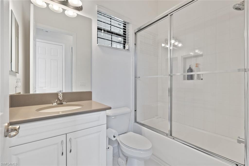 13750 Callisto Avenue Naples, FL 34109 - Photo 19 of 46 a bathroom with a granite countertop sink a toilet and shower