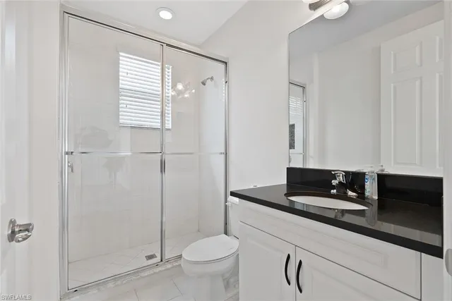 a bathroom with a granite countertop sink a toilet and shower