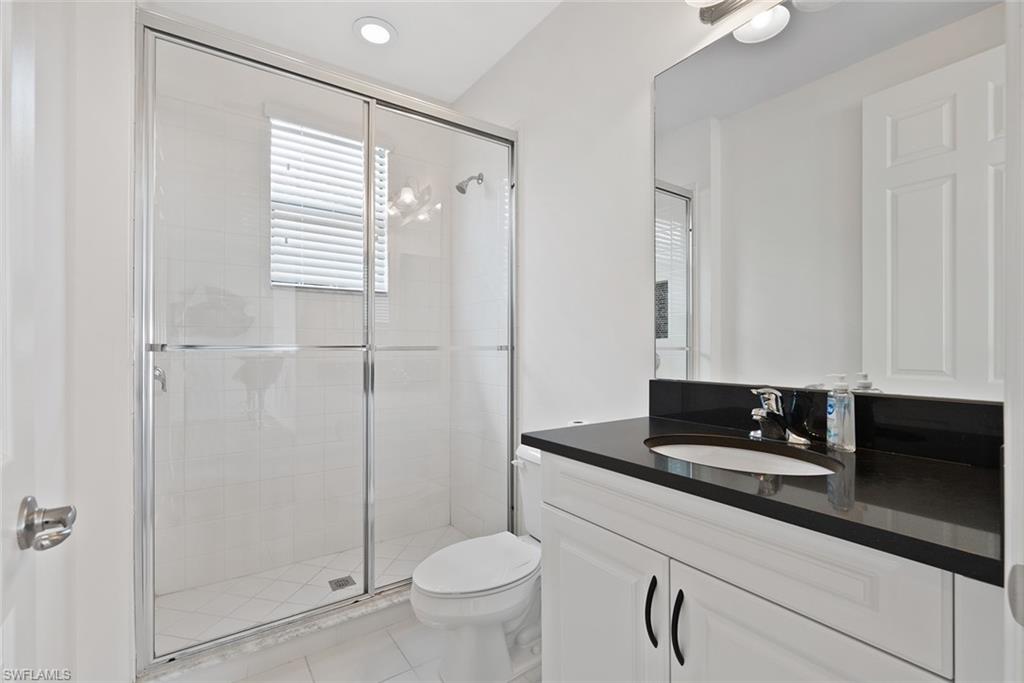 13750 Callisto Avenue Naples, FL 34109 - Photo 23 of 46 a bathroom with a granite countertop sink a toilet and shower