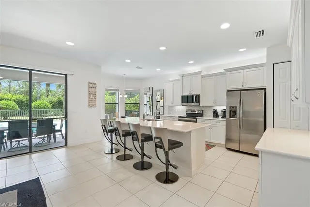 a kitchen with a dining table chairs and refrigerator