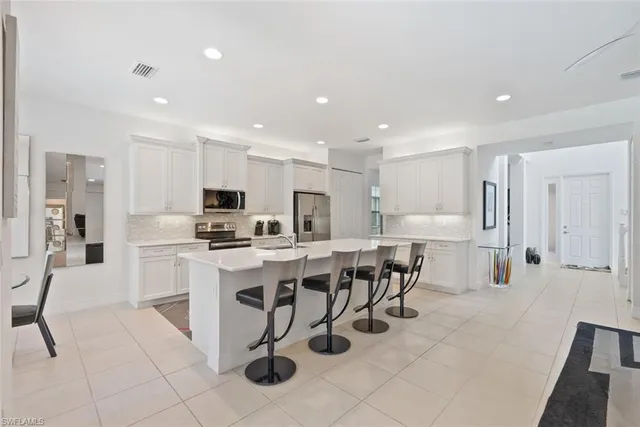 a kitchen with appliances a sink a counter top space and cabinets