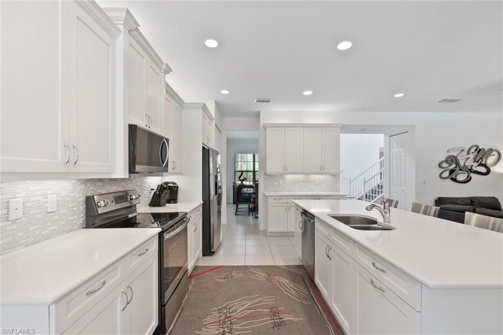 13750 Callisto Avenue Naples, FL 34109 - Photo 7 of 46 a kitchen with a sink stainless steel appliances and cabinets