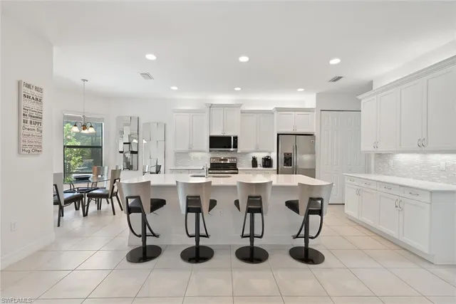 a kitchen with a sink and chairs