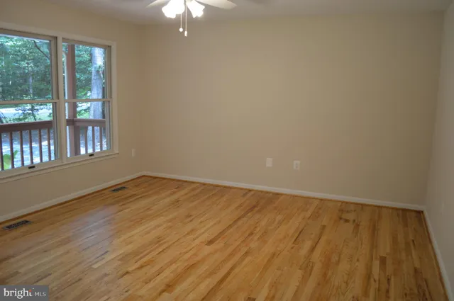 a view of empty room with wooden floor