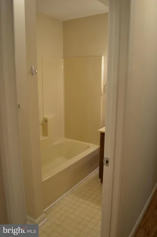 a view of an empty room with wooden floor and closet