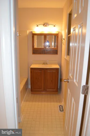 an empty room with wooden floor & closet area