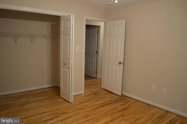 a view of an empty room with a chandelier fan