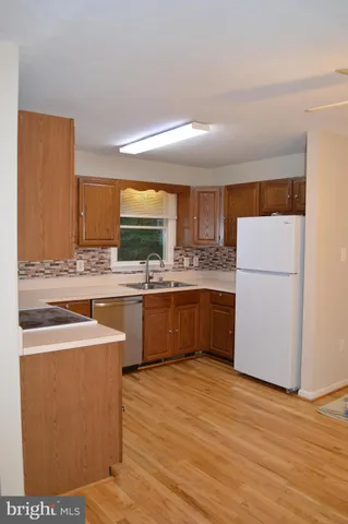 a large kitchen with a stove a sink dishwasher and a microwave