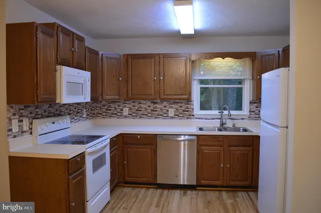 a kitchen with stainless steel appliances granite countertop a sink stove and wooden floor