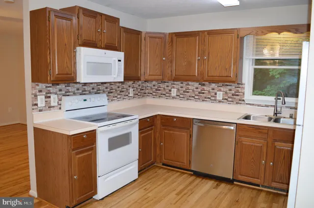 a kitchen with a sink a refrigerator and cabinets