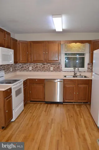 a kitchen with a sink a refrigerator and cabinets