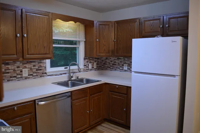 a view of a house with a yard potted plants and large tree