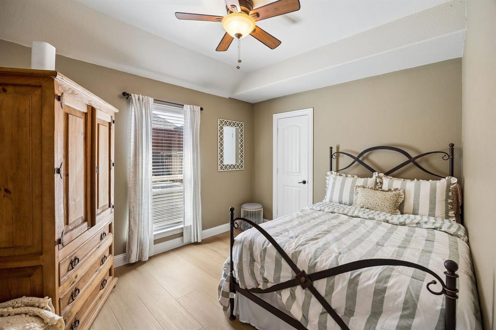 3917 Gatewick Drive Rockwall, TX 75087 - Photo 18 of 34 a bedroom with a bed and a chandelier
