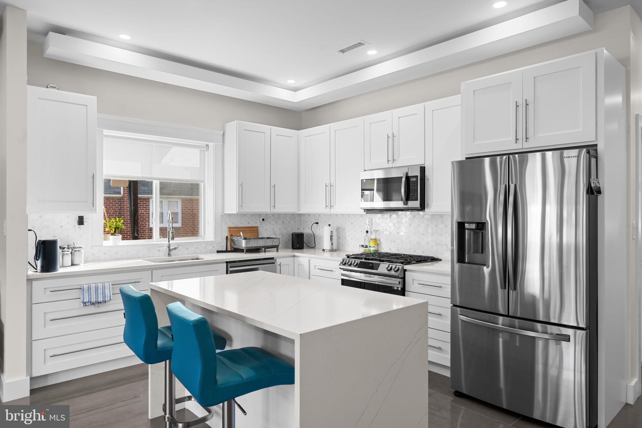 9975 Woodfern Road Philadelphia, PA 19115 - Photo 13 of 35 a kitchen with stainless steel appliances a refrigerator stove microwave and cabinets