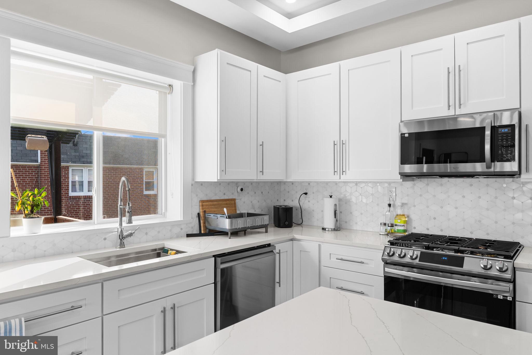 9975 Woodfern Road Philadelphia, PA 19115 - Photo 14 of 35 a kitchen with a sink stove and microwave