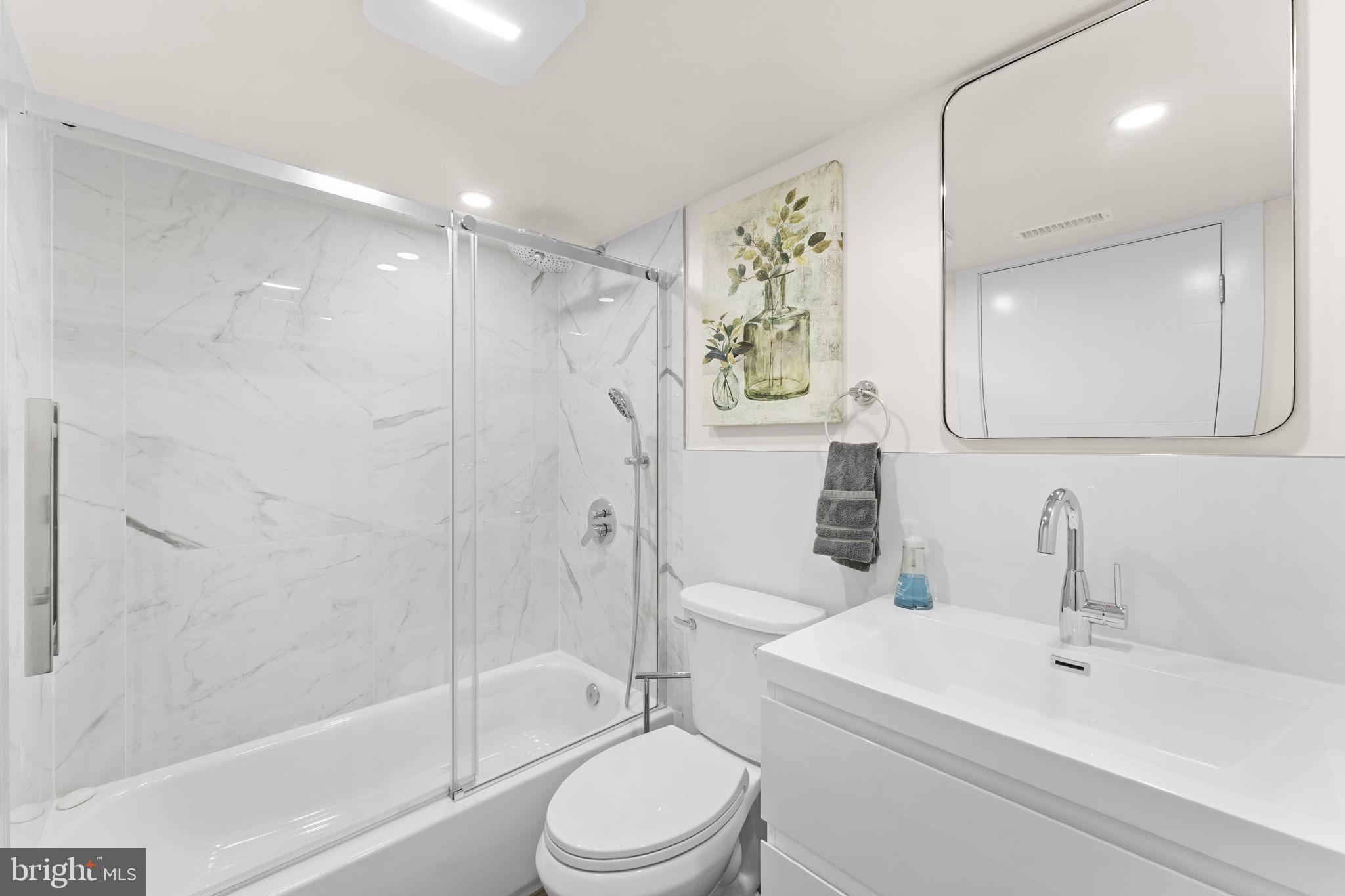 9975 Woodfern Road Philadelphia, PA 19115 - Photo 29 of 35 a bathroom with a toilet sink vanity tub and shower