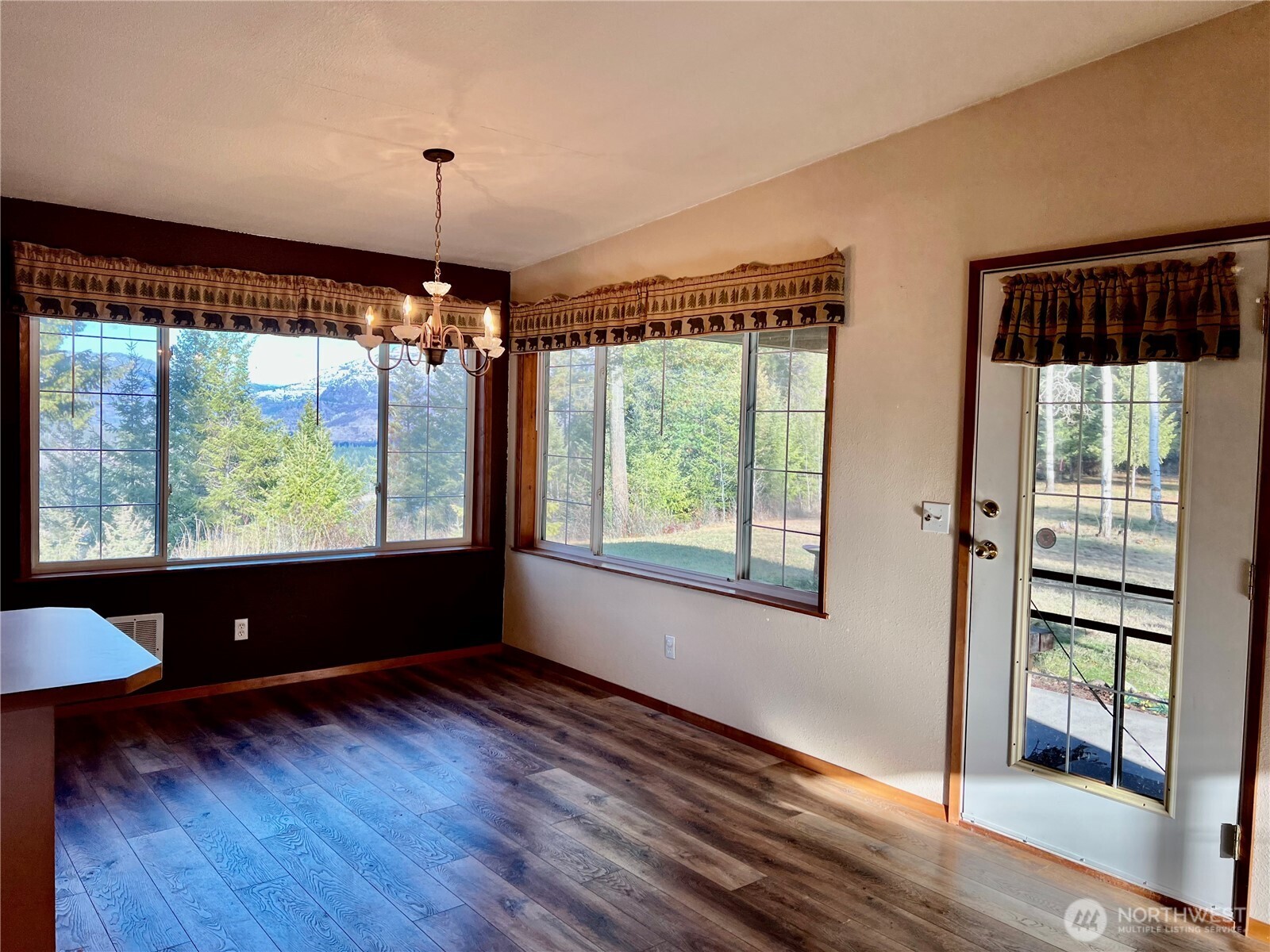 4084 Deep Lake Boundary Road Colville, WA 99114 - Photo 14 of 40 a view of a room with wooden floor a chandelier window and wooden floor
