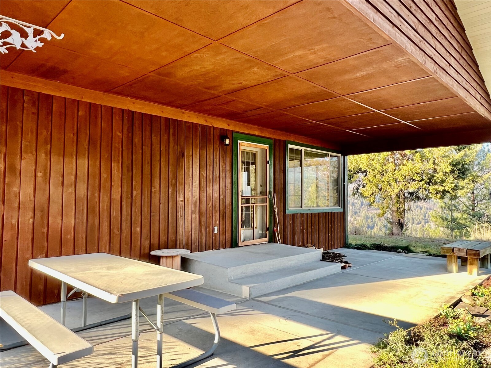 4084 Deep Lake Boundary Road Colville, WA 99114 - Photo 25 of 40 a view of a patio with a table and chairs under an umbrella