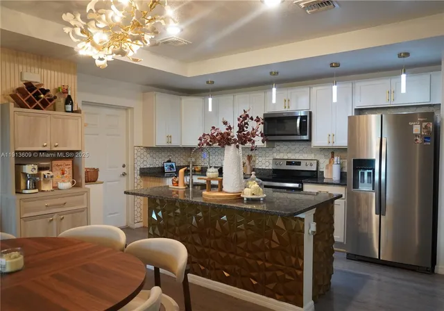 a kitchen with kitchen island a refrigerator stove and microwave