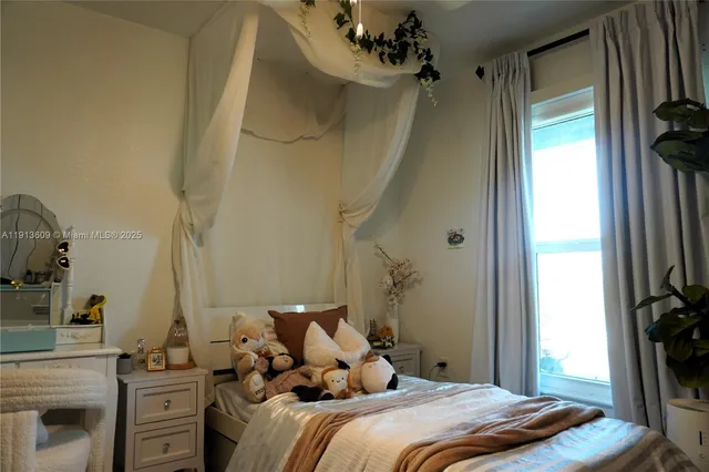 a bedroom with a bed and a flat tv screen on the dresser