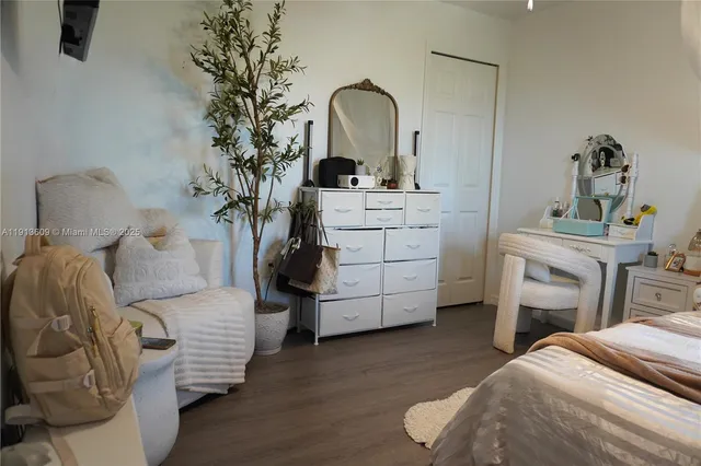 a bedroom with a bed and a potted plant