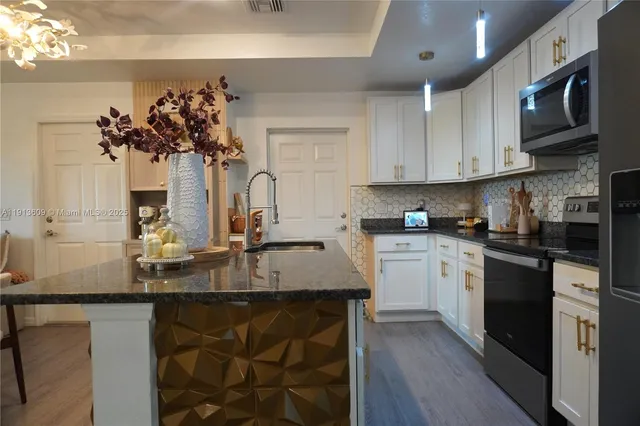 a kitchen with stainless steel appliances granite countertop a sink stove and microwave