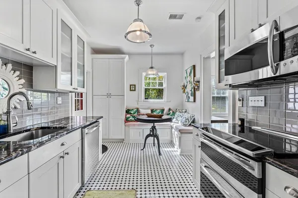 a kitchen with stainless steel appliances a sink stove top oven and cabinets