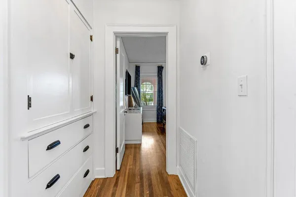 a view of a hallway with wooden floor and closet
