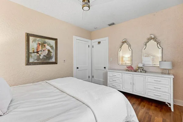 a spacious bedroom with a bed and a dresser