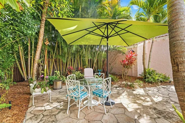 a patio with a table and chairs under an umbrella