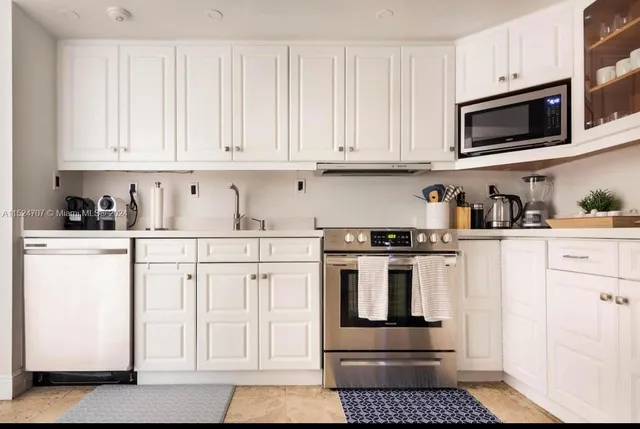 a kitchen with white cabinets and stainless steel appliances