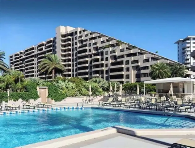 a front view of building with outdoor space and swimming pool