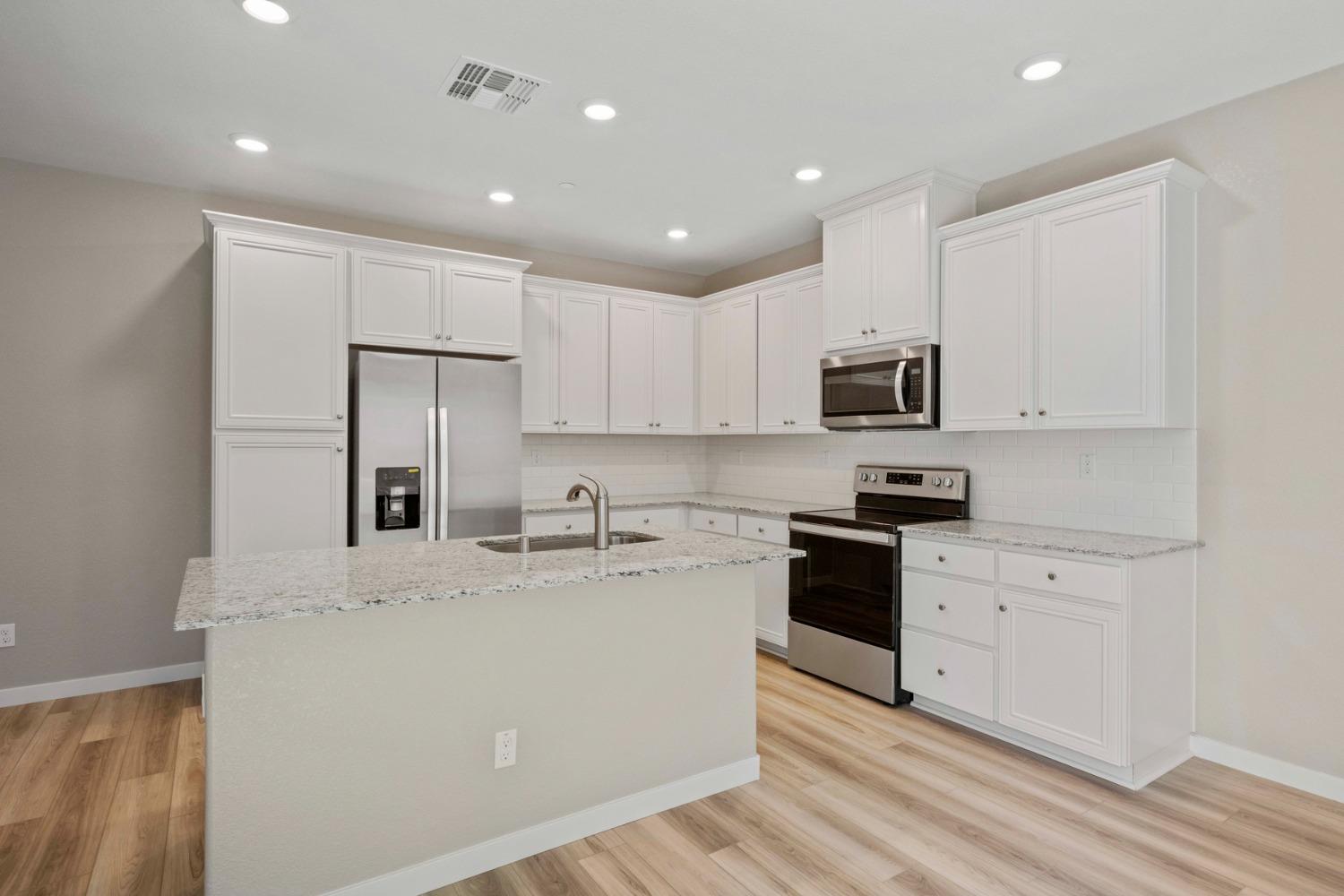 2548 Bog Street Lincoln, CA 95648 - Photo 9 of 21 a kitchen with kitchen island a white cabinets and stainless steel appliances