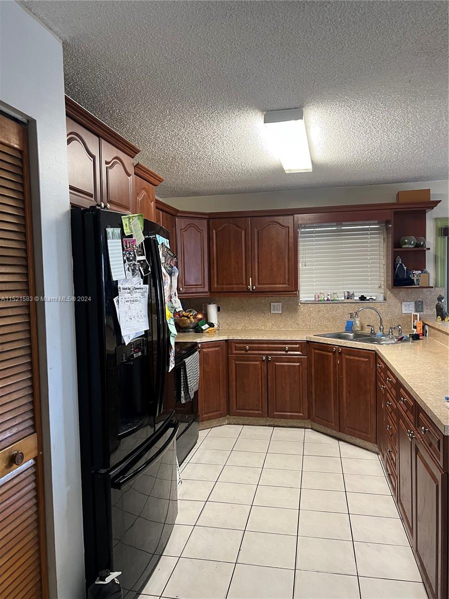 3196 West 79th Place Hialeah, FL 33018 - Photo 3 of 19 a kitchen with a refrigerator a sink and cabinets