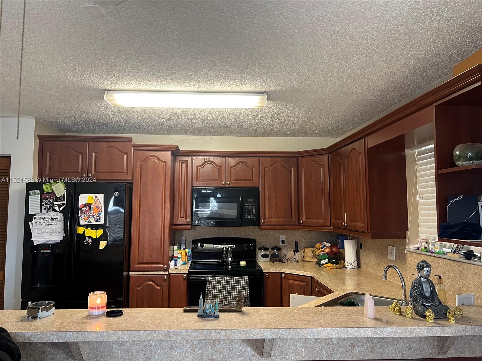 3196 West 79th Place Hialeah, FL 33018 - Photo 4 of 19 a kitchen with granite countertop a refrigerator stove and microwave